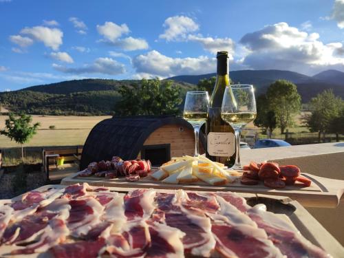 a table with meat and wine glasses and a fireplace at Chez Fabien et Céline in Aunat