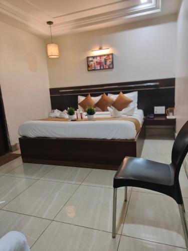 a bedroom with a large bed and a chair at Hotel Shirdi Park Inn 80 Meters From Sai Samadhi Temple in Shirdi