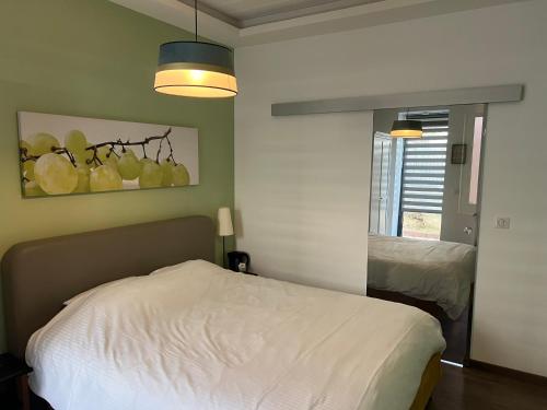 a bedroom with a white bed and a mirror at De Tussenstop in Villefranche-sur-Saône