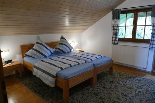 a bedroom with a bed with blue sheets and a window at Bushof - Leben auf dem Land in Sulzbach an der Murr
