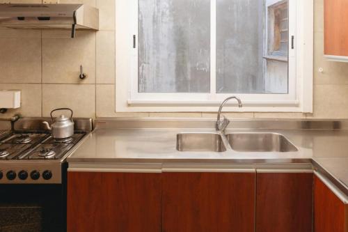 a kitchen with a sink and a stove at Departamento Vista Huapi in San Carlos de Bariloche