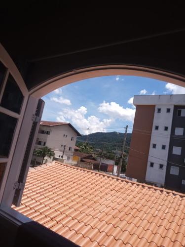 una ventana con vistas a un techo de azulejos en Suite região central, en Ubatuba