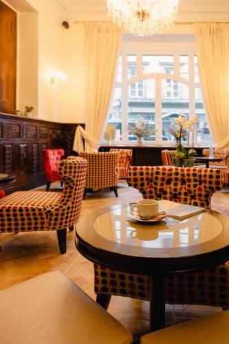 a living room with a table and chairs at Grand Hôtel de l'Europe - Morlaix Centre in Morlaix