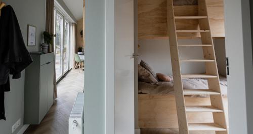 een kamer met een houten wenteltrap in een huis bij Boslodge Bosmus - 4 personen - NIEUW in Nunspeet