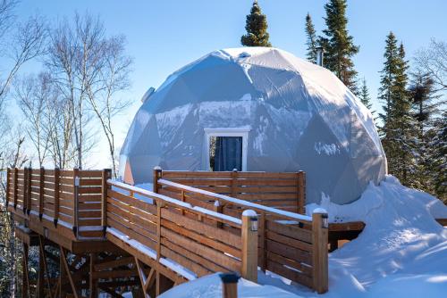 une maison igloo dans la neige dans les bois dans l'établissement Nørdika Charlevoix, à Baie-Saint-Paul