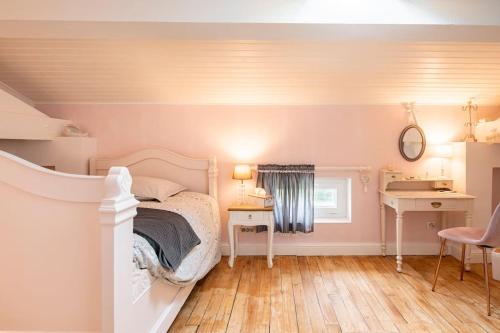 um quarto com uma cama e uma secretária. em La Chambre "Rose" d'Hauterive em Villeneuve-sur-Lot