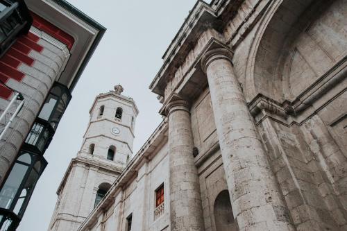 a building with a clock tower in the background at Hotel El Coloquio in Valladolid