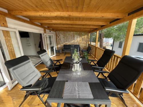 eine Terrasse mit einem Tisch und Stühlen auf einer Terrasse in der Unterkunft Getaway Mobile Home in Drage