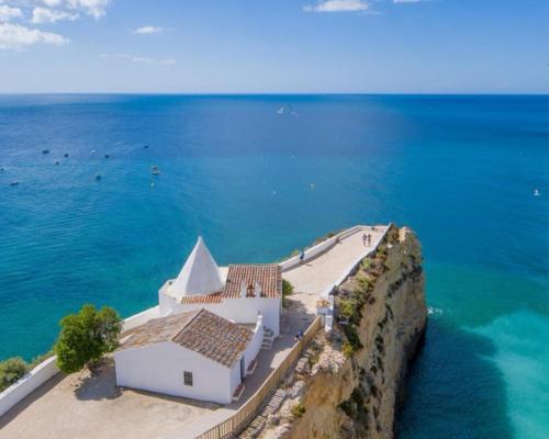 a white church on a cliff next to the ocean at Linda Vista Mar T1, A-C, Wi-Fi, Porches in Porches
