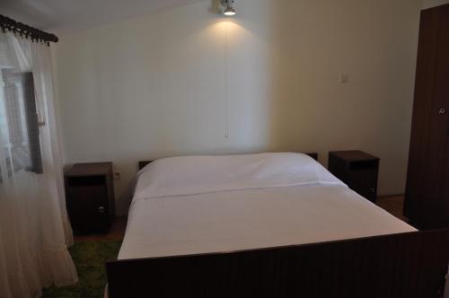 ein Schlafzimmer mit einem Bett und zwei Nachttischen in der Unterkunft Villa VELA BORKA in Podgora