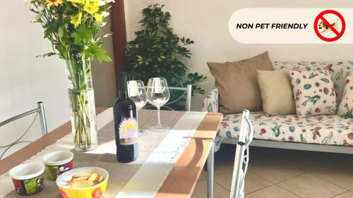 una mesa con dos copas de vino y un sofá en Casa in Maremma Tuscany Village, en Scarlino