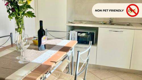 a kitchen with a table with a bottle of wine at Casa in Maremma Tuscany Village in Scarlino