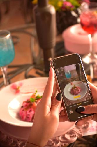 a person holding a cell phone in front of a plate of food at Casa Rosa Hotel & Spa in San Cristóbal de Las Casas