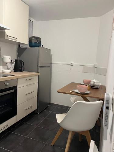 Il comprend une petite cuisine avec une table et une chaise blanche. dans l'établissement F2 LOUIS BLANC CANNES, à Cannes