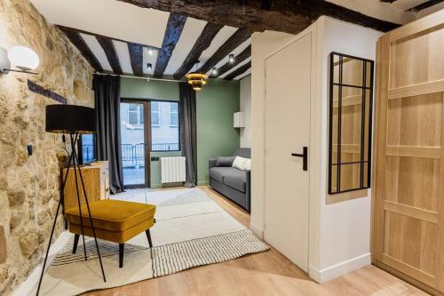 un salon avec une chaise jaune et un canapé dans l'établissement Typical Parisian Apartment in Le Marais#4 pers, à Paris