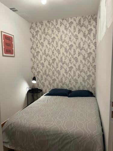 1 dormitorio con cama con colcha gris en F2 LOUIS BLANC CANNES, en Cannes