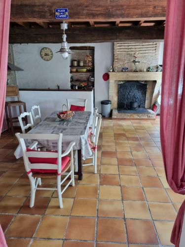une salle à manger avec une table et des chaises et une cheminée dans l'établissement Mimosa, à Barie