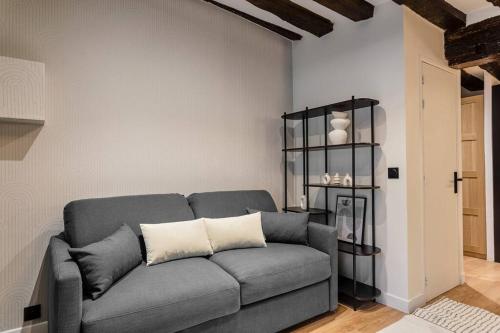 - un salon avec un canapé gris et une étagère dans l'établissement Typical Parisian Apartment in Le Marais#4 pers, à Paris