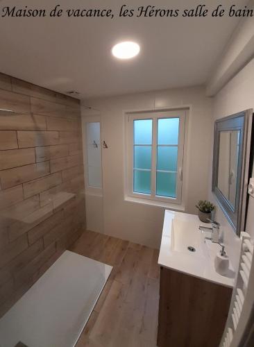 une salle de bain avec un lavabo, une baignoire et un miroir dans l'établissement Domaine de l'Ermitage, à Rue