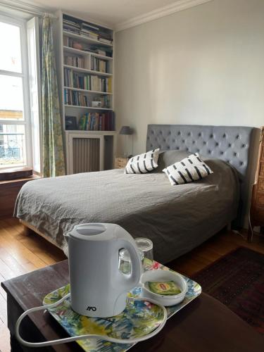 - une chambre avec un lit et une table avec une bouilloire dans l'établissement Chambre d'hôte, à Versailles