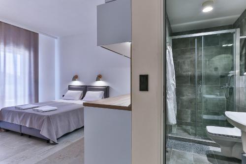 1 dormitorio con cama, ducha y lavamanos en Apartments Magic box II, en Kruče