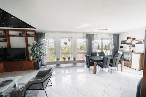 a living room with a table and chairs at Einzigartiger Panoramablick zur Schwäbische Alb in Altenriet