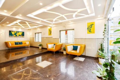 an office lobby with orange chairs and plants at THE MARELLA SUITES in Bangalore