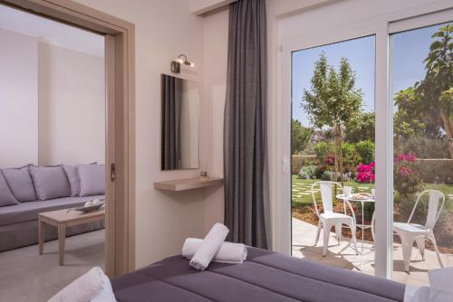 1 dormitorio con puerta corredera de cristal que da a un patio en Mear Luxury Holiday Homes - Cretan Sunny Gems, en Kountoura Selino