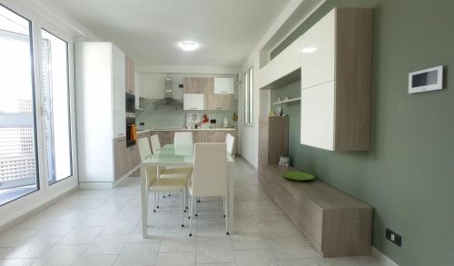 a kitchen with a table and chairs in a room at Terrazza Bianca in Vittoria