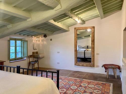 1 dormitorio con cama y espejo en la pared en Holiday Home La Pace, en Pescaglia