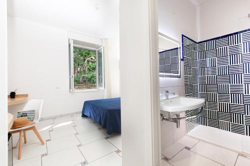- une salle de bains blanche pourvue d'un lavabo et d'un lit dans l'établissement Hotel Piccolo Paradiso, à Massa Lubrense