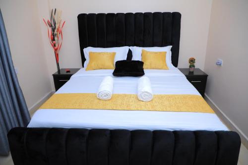 a black cat sitting on top of a bed at Apartment in kisii Milimani in Kisii