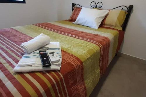 a bed with a remote control on top of it at Hermosa Suit en la Playa in Data de Villamil