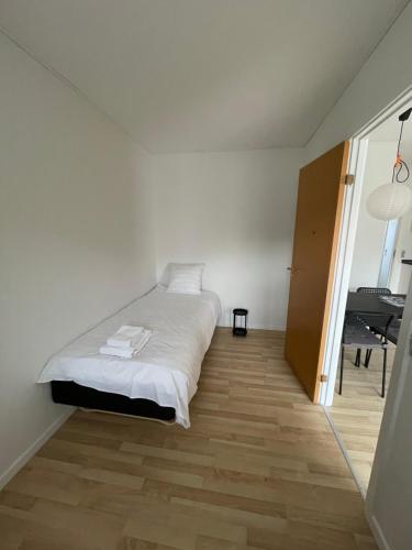 a white bedroom with a bed and a piano at Kragenæshus in Torrig