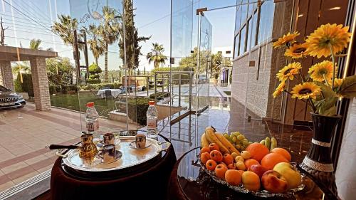 una mesa de cristal con frutas y verduras. en فندق الفاروق en Ash Shumaysānī
