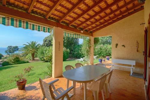 une salle à manger avec une table et des chaises sur un patio dans l'établissement VILLA 200 m de la plage La Liscia TIUCCIA, à Casaglione