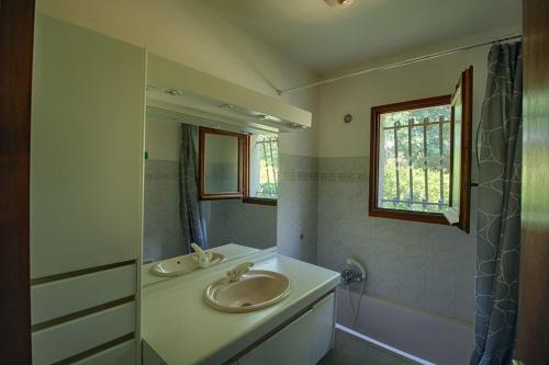 une salle de bain avec deux lavabos et un miroir dans l'établissement VILLA 200 m de la plage La Liscia TIUCCIA, à Casaglione