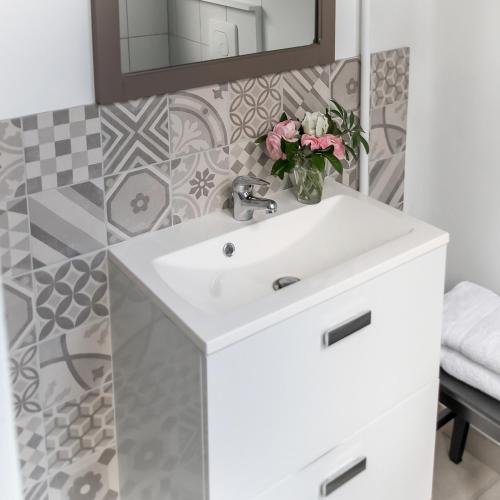 une salle de bain avec un lavabo blanc et un miroir dans l'établissement Appartement Versailles Centre, à Versailles