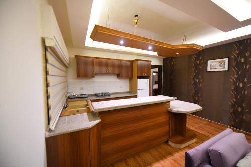 uma cozinha com armários de madeira e uma bancada em فندق الفاروق em Ash Shumaysānī