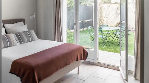 une chambre avec un lit et un balcon avec une table dans l'établissement Appartement Versailles Centre, à Versailles