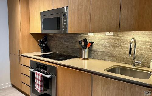 La cuisine est équipée d'un évier et d'un four micro-ondes. dans l'établissement Cozy 3 Bedrooms Condo, à Toronto