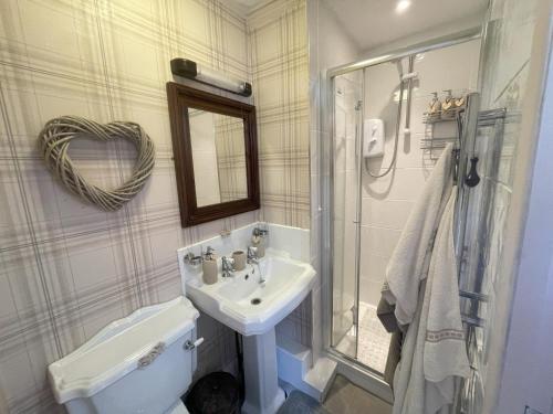 La salle de bains est pourvue d'un lavabo, de toilettes et d'un miroir. dans l'établissement The Old Merchants House - The Highlands Room, à Southampton