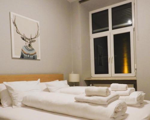 a bedroom with two beds with white towels on them at Apartament Donnka in Krakow