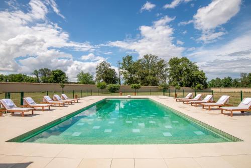a pool with chaise lounge chairs and a swimming pool at Les Louteaux - Splendide Château du XVIII -Piscine- Parc de Lamas in Chézy