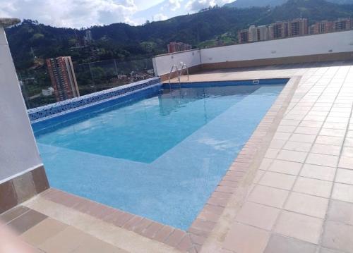 uma grande piscina azul no topo de um edifício em Impecable y lujoso apartamento para una estadía unica em Medellín
