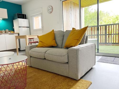 a living room with a gray couch with yellow pillows at Le Joséphine in Nantes