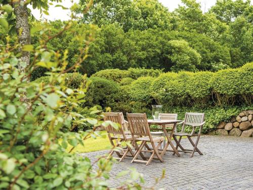 três cadeiras e uma mesa de madeira num jardim em Hygge Hüs von Appartements & Mehr em Kampen