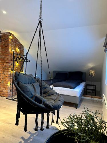 a hanging chair in a room with a bed at Arctic Loft in Skjervøy