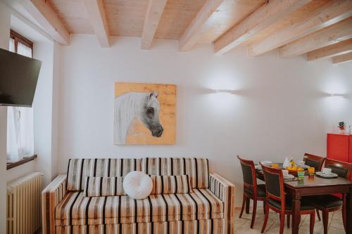 un salon avec un canapé et une peinture de cheval dans l'établissement CAMPOLIVO ECOLODGES All HOUSE, à Gargnano