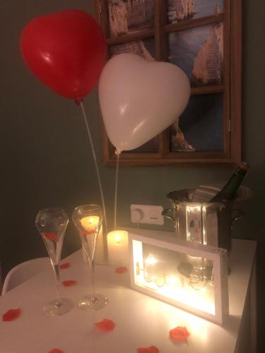 a balloon and two glasses and a candle on a table at La Carola in Bordeaux-Saint-Clair